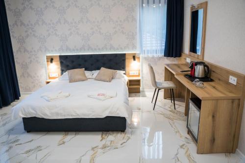 a hotel room with a bed and a desk and a desk at Хотелски комплекс Релакс in Rudozem
