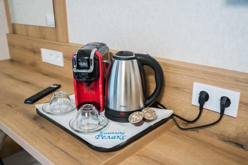 a red and black coffee maker on a counter at Хотелски комплекс Релакс in Rudozem