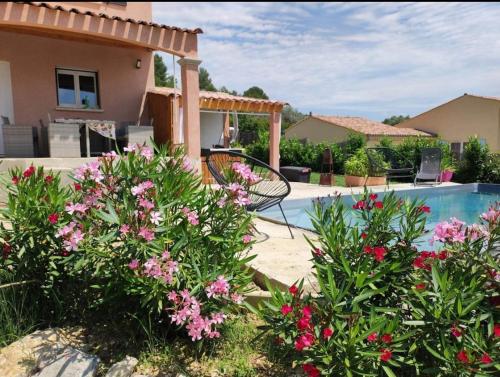 une maison avec piscine et fleurs roses dans l'établissement Magnifique villa au coeur de la Provence, à Peyruis