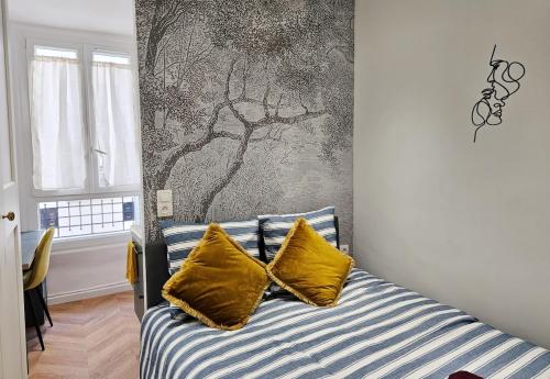 a bedroom with a bed with two yellow pillows at Charme apt a Paris ideal for 3p in Paris