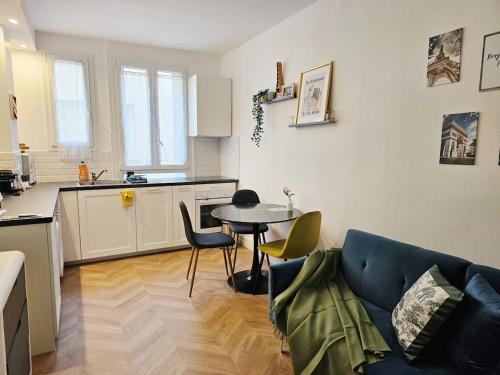 une cuisine et un salon avec une table et des chaises dans l'établissement Charme apt a Paris ideal for 3p, à Paris