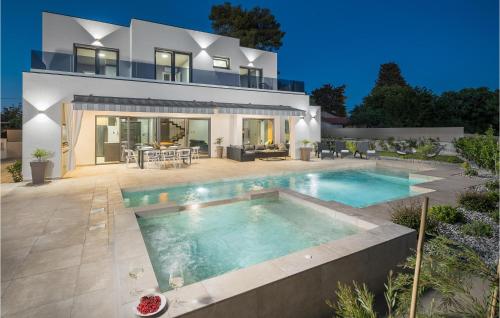 a villa with a swimming pool in front of a house at 4 Bedroom Beautiful Home In Banjole in Banjole