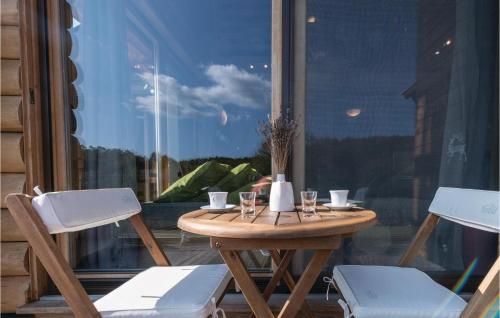 a table and two chairs on a porch with a window at Beautiful Home In Gornji Zvecaj in Gornji Zvečaj