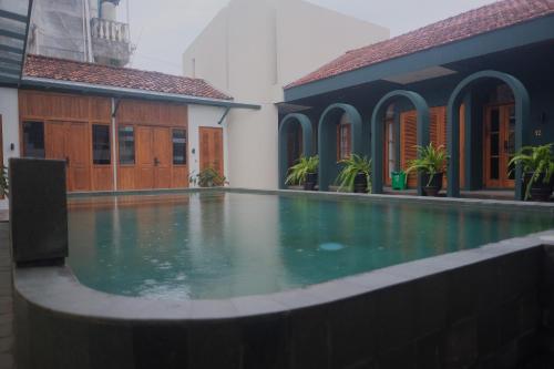 a swimming pool in front of a building at Agung Guest House by RF in Timuran