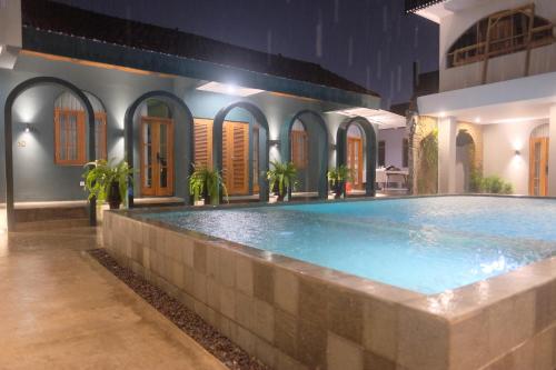 a swimming pool in front of a house at Agung Guest House by RF in Timuran