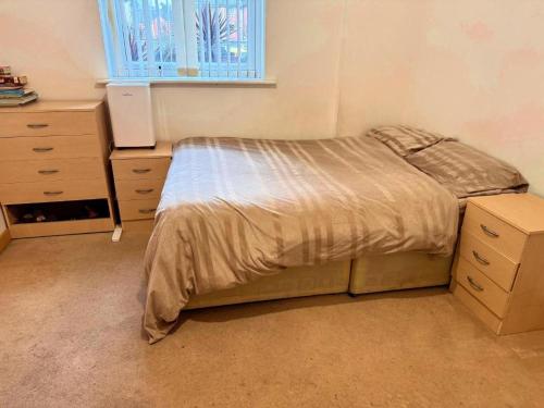 a bedroom with a bed and a dresser and a window at Cozy Private Room with Free Wi-Fi in Colchester