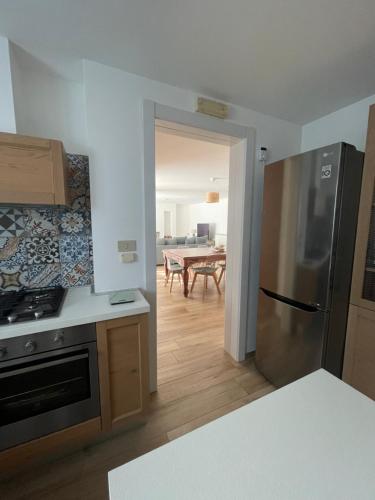 a kitchen with a stainless steel refrigerator and a dining room at Residenza Sant'Angelo in Citta' Sant'Angelo