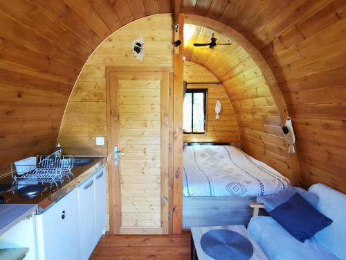 - une chambre dans une cabane en rondins avec un lit dans l'établissement Ma cabane au fond du jardin, à Porto-Vecchio