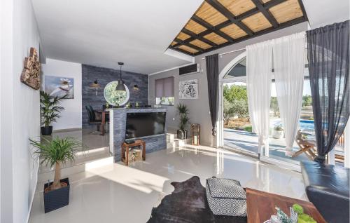a living room with a fireplace and a large window at Four-Bedroom Holiday Home In Skradin-Dubavice in Čulišić