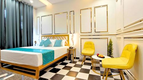 a bedroom with a bed and two yellow chairs at Asapin Vanymahal in Rāmnagar