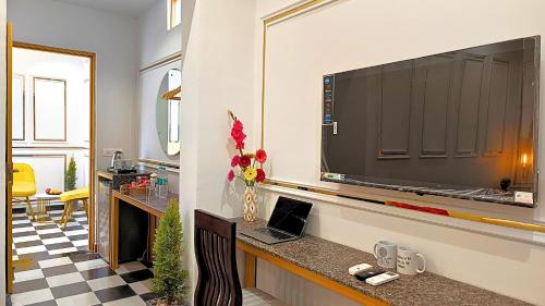 a living room with a large television on a wall at Asapin Vanymahal in Rāmnagar