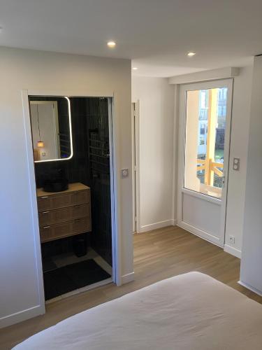 - une chambre avec une salle de bains pourvue d'un miroir et d'un lavabo dans l'établissement Sea view apartment with balcony, à Saint-Malo