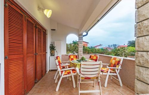 patio ze stołem i krzesłami na balkonie w obiekcie Holiday Home Betiga With Sea View Vi w mieście Barbariga