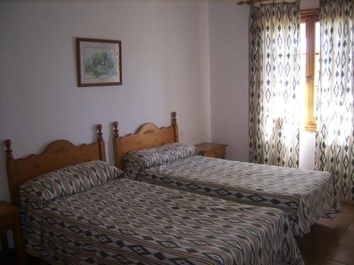 two beds in a bedroom with a window at Villa Isabel in Cala'n Bosch