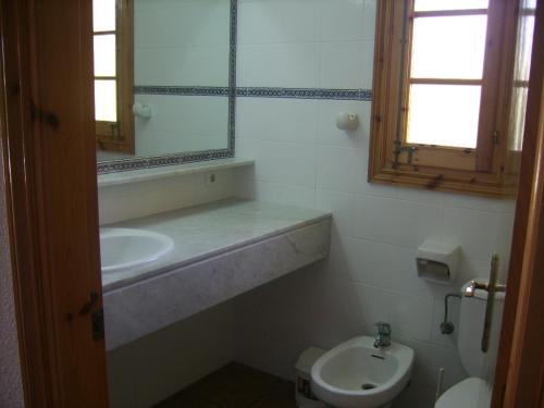 a bathroom with a sink and a mirror and a toilet at Villa Isabel in Cala'n Bosch