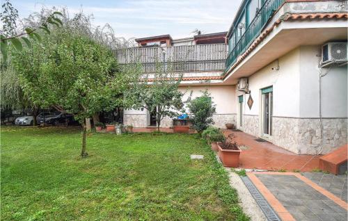 une maison avec une cour et un arbre en face de celle-ci dans l'établissement 2 Bedroom Cozy Apartment In Napoli, à Naples