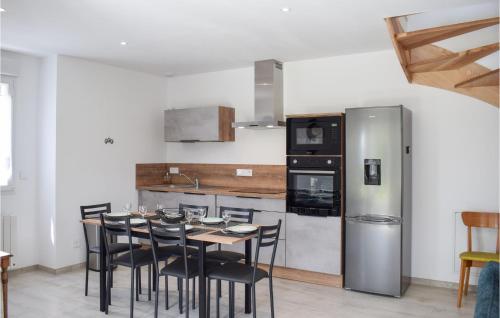 a kitchen with a table and chairs and a refrigerator at Awesome Home In Canihuel in Canihuel