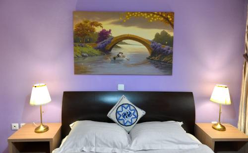 a bedroom with a bed with a painting on the wall at Patriko in Arachova