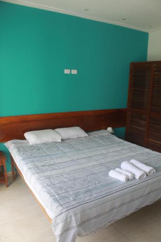 a bedroom with a bed with two towels on it at sunshine home in Paraty