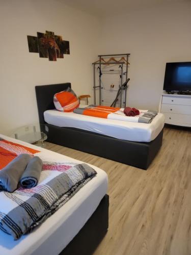 two beds in a room with a flat screen tv at Ferienwohnung kopp in Plauen in Plauen