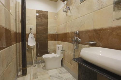 a bathroom with a toilet and a sink at Holiday Out Hotel in Jodhpur