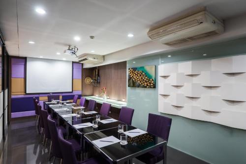 a dining room with tables and purple chairs at Beyond Suite in Bangkok