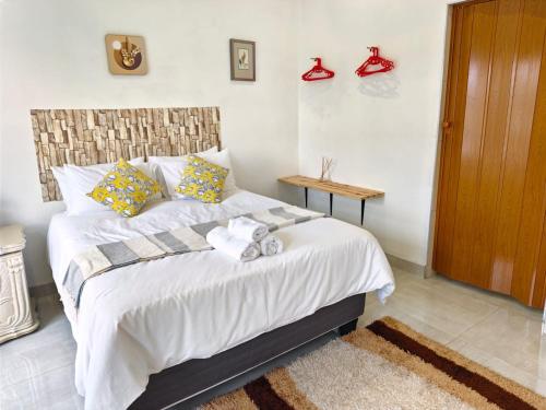 a bedroom with a bed with shoes on the wall at Masingita Guest House in Graskop