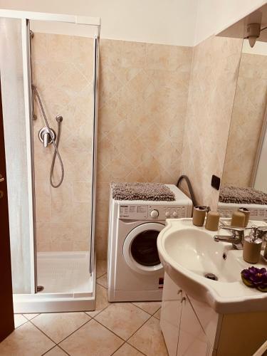 a bathroom with a washing machine and a sink at Bella Vista Poggi - 180 Grad fantastischer Meerblick & Pool in Poggi