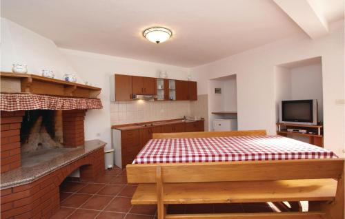 kuchnia ze stołem i ceglanym kominkiem w obiekcie Apartment Plomin Iv w mieście Plomin