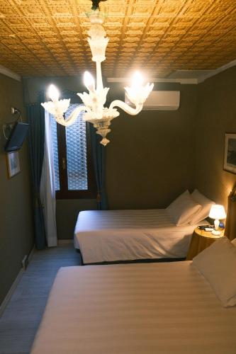 a bedroom with two beds and a chandelier at H O T E L S A N G A L L O l in Venice