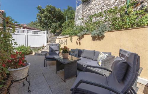 a patio with chairs and a couch and a table at Two-Bedroom Apartment In Rabac in Rabac
