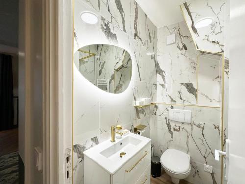 une salle de bain avec un lavabo blanc et un miroir dans l'établissement Apt lux walk to Opera Lafayette, à Paris