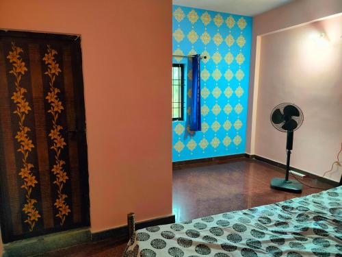a bedroom with a bed and blue and orange walls at Single Room Attached Bathroom in Kārwār
