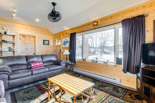 a living room with a leather couch and a table at Lakefront Cabin with Shared Beach in Cecil! in Shawano