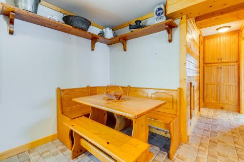 a dining room with a wooden table and a bench at Lakefront Cabin with Shared Beach in Cecil! in Shawano
