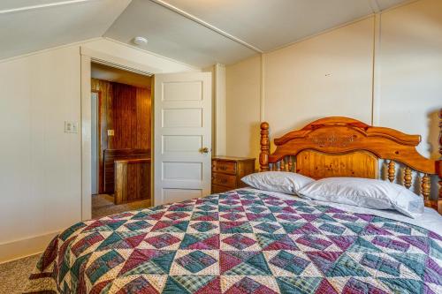 a bedroom with a large bed with a colorful quilt at Lakefront Cabin with Shared Beach in Cecil! in Shawano