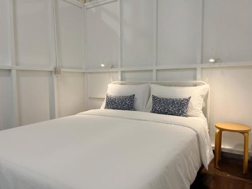 a white bedroom with a large white bed with pillows at Kaba Home Melaka in Melaka