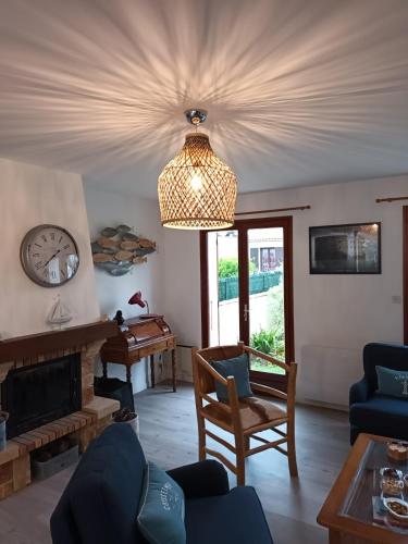 d'un salon avec une cheminée et un lustre. dans l'établissement Le saule ile d' oleron, à Saint-Pierre-dʼOléron