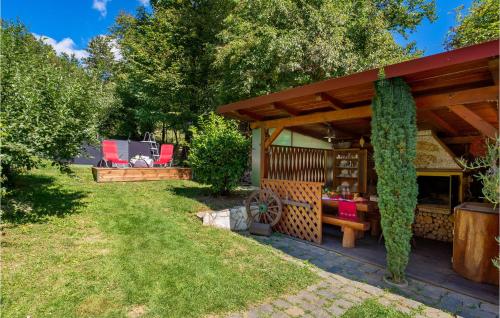 a wooden pergola with a table in a yard at Awesome Home In Lic With Wifi in Lič