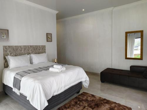 a bedroom with a large bed and a couch at Masingita Guest House in Graskop