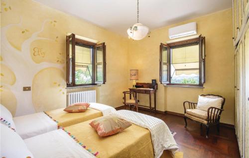 a bedroom with two beds and a desk and windows at 2 Bedroom Gorgeous Home In Montebuono in Montebuono