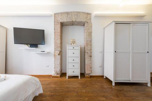 a bedroom with a bed and a tv on a wall at LUMEN Old Town Loft in Cagliari