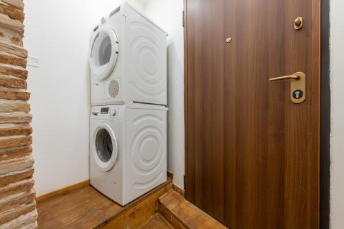 a washer and dryer in a room next to a door at LUMEN Old Town Loft in Cagliari