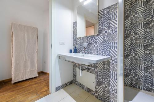 a bathroom with a sink and a mirror at LUMEN Old Town Loft in Cagliari