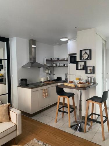 une cuisine avec une table et des chaises dans une pièce dans l'établissement Le Traverse élégant T2 au cœur du centre ville, à Brest