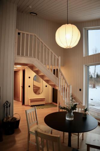 a living room with a staircase and a table and chairs at Metsajärve puhkemaja in Otepää