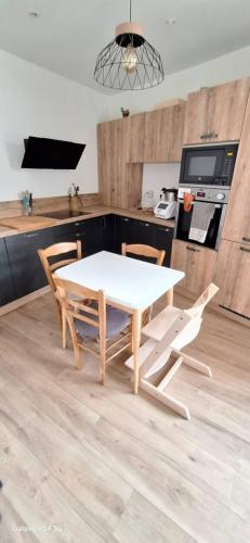 une table blanche et des chaises dans une cuisine dans l'établissement Le Fiacre, à Nancy