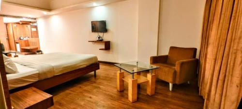 a hotel room with a bed and a chair at The Sky Comfort, Ahmedabad in Ahmedabad
