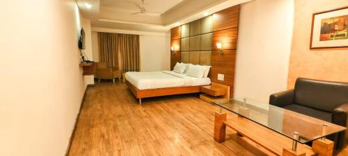 a hotel room with a bed and a couch at The Sky Comfort, Ahmedabad in Ahmedabad