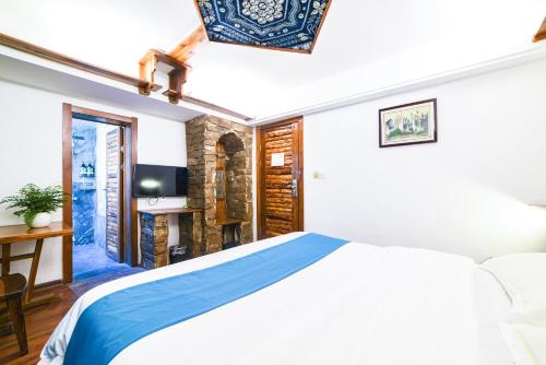 a bedroom with a bed and a desk and a television at Destination Youth Hostel in Zhangjiajie